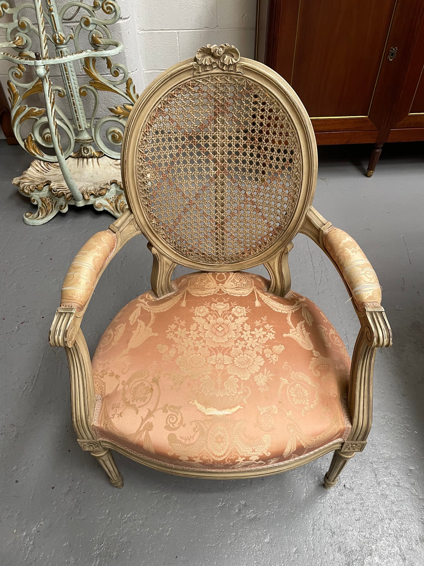 French Louis XV style cane back and upholstered seat fauteuil. With original paint and fabric is in original used condition with some stains and tears. Overall they are in good original used condition. Circa 1950's.