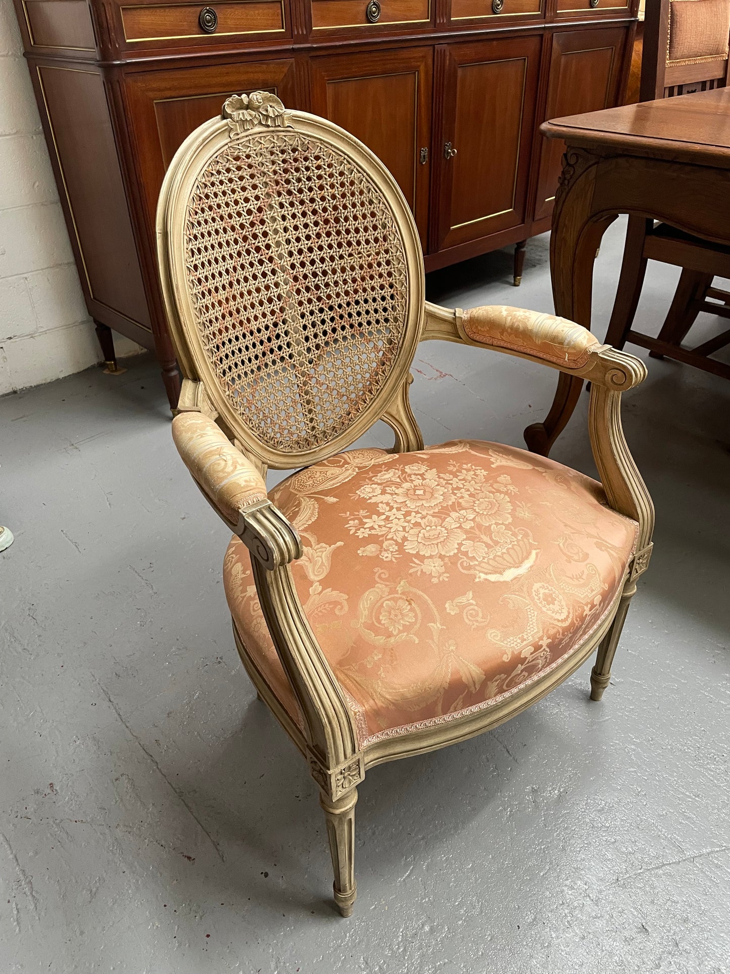 French Louis XV style cane back and upholstered seat fauteuil. With original paint and fabric is in original used condition with some stains and tears. Overall they are in good original used condition. Circa 1950's.