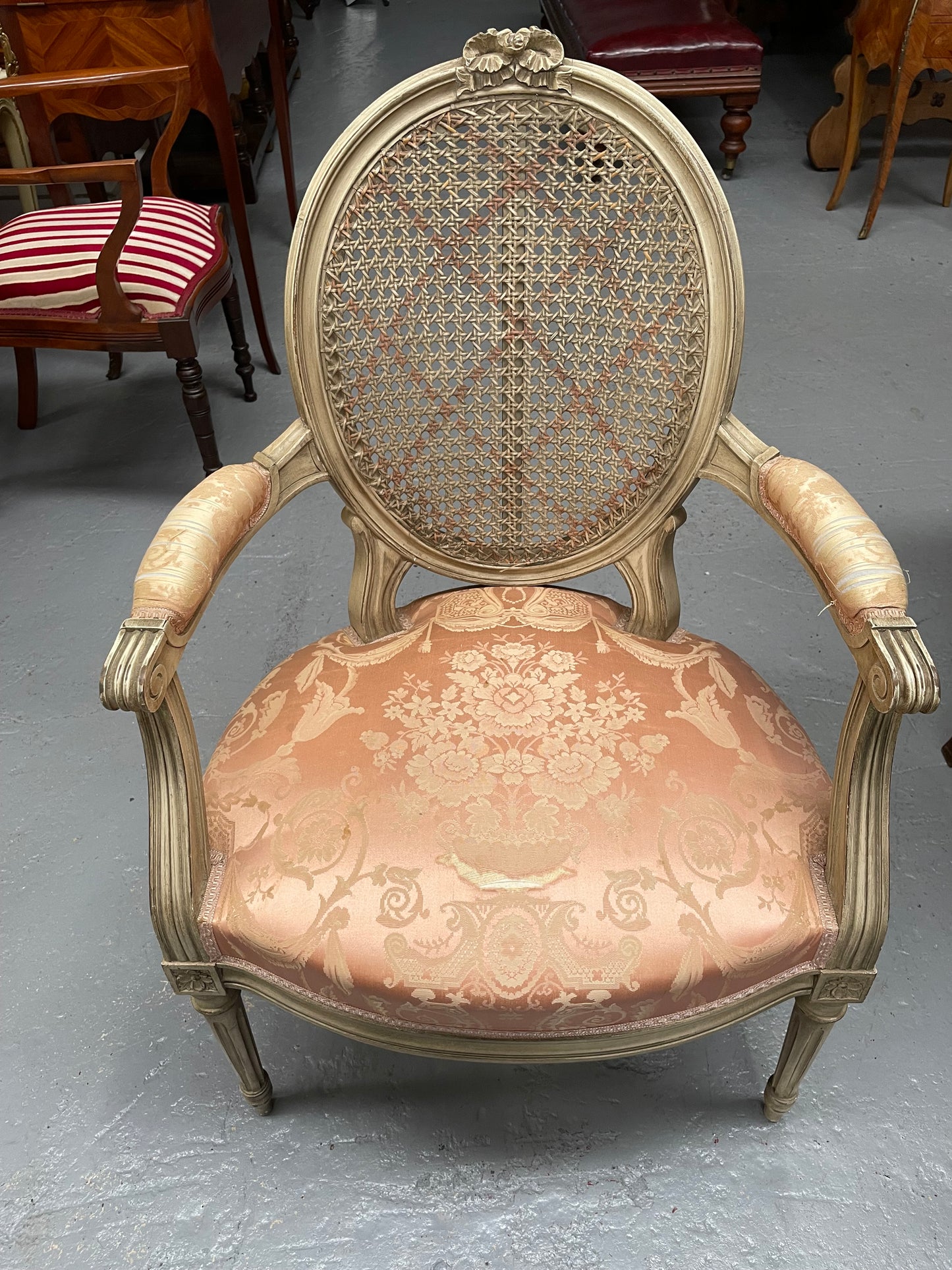 French Louis XV style cane back and upholstered seat fauteuil. With original paint and fabric is in original used condition with some stains and tears. Overall they are in good original used condition. Circa 1950's.