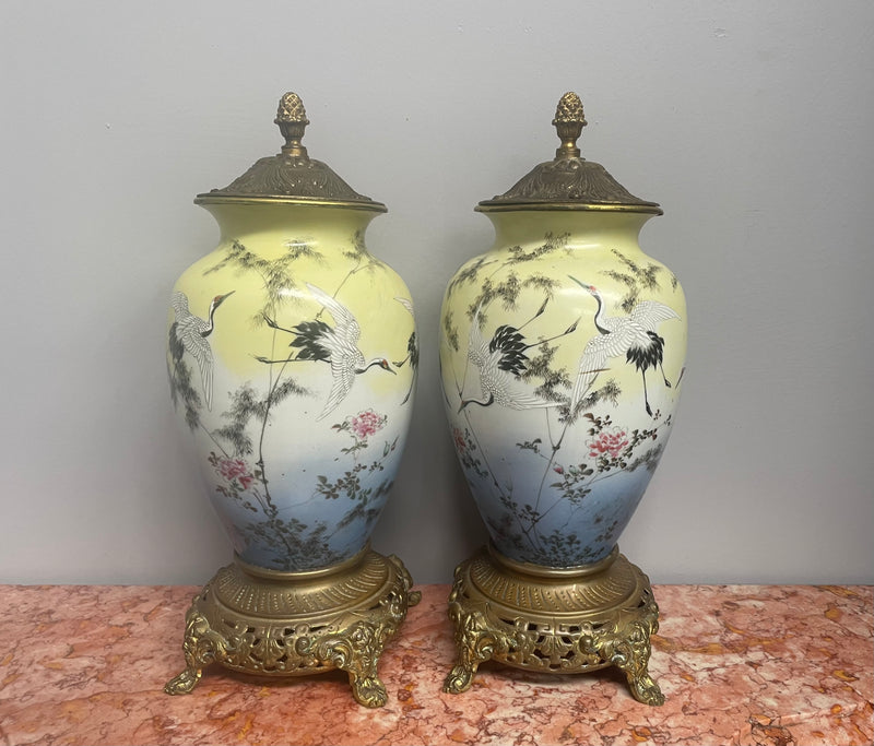 Attractive pair of Japanese urns. Hand painted depicting cranes and with brass mounts. In good original condition. Please see photos as they form part of the description.