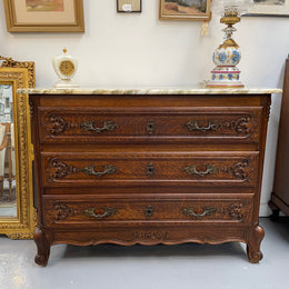Louis XV style three drawer commode. Featuring carving on all three drawers with elegant bronze handles and escutcheons. It has an impressive marble top and has been sourced directly from France. It is in good original detailed condition.
