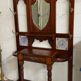 Lovely Edwardian single drawer shield mirror mahogany hall stand. It has 6 hooks for hanging and two pretty decorative blue and white tiles. In good original condition