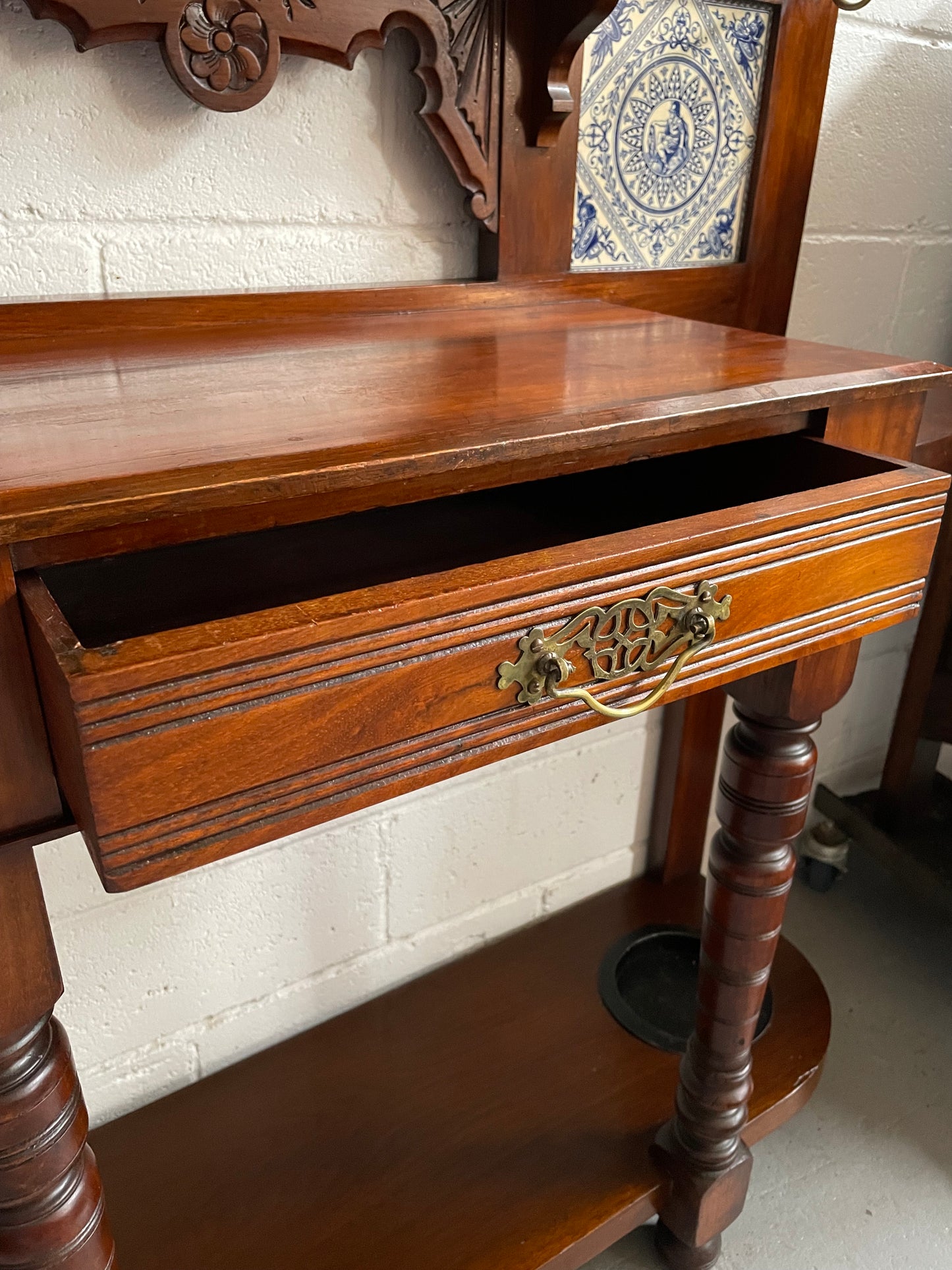 Lovely Edwardian single drawer shield mirror mahogany hall stand. It has 6 hooks for hanging and two pretty decorative blue and white tiles. In good original condition