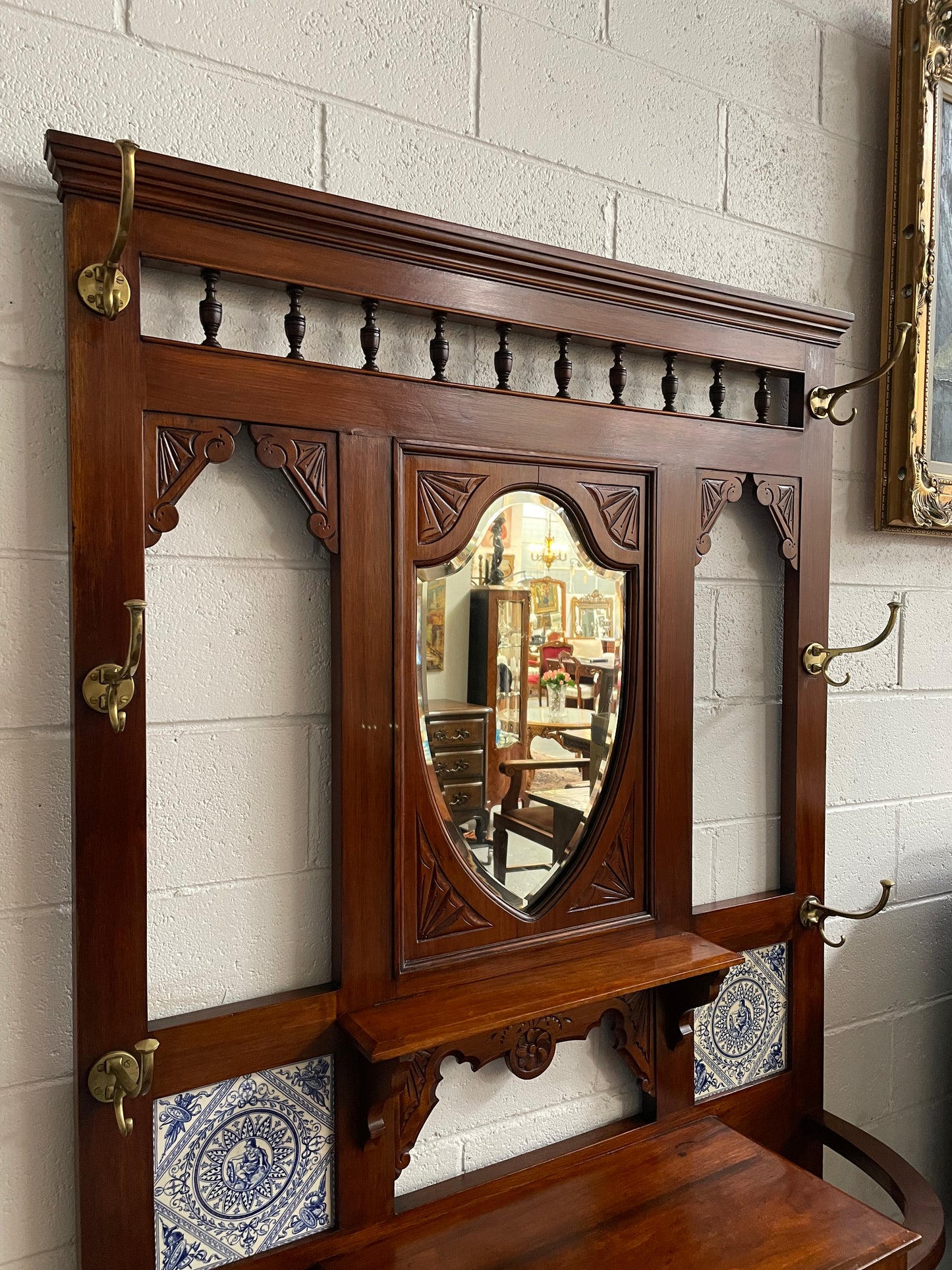 Lovely Edwardian single drawer shield mirror mahogany hall stand. It has 6 hooks for hanging and two pretty decorative blue and white tiles. In good original condition