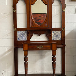 Lovely Edwardian single drawer shield mirror mahogany hall stand. It has 6 hooks for hanging and two pretty decorative blue and white tiles. In good original condition