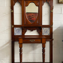 Lovely Edwardian single drawer shield mirror mahogany hall stand. It has 6 hooks for hanging and two pretty decorative blue and white tiles. In good original condition