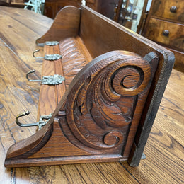 French oak wall coat rack with four decorative hooks and shelf. It has been sourced from France and is in good original condition. 