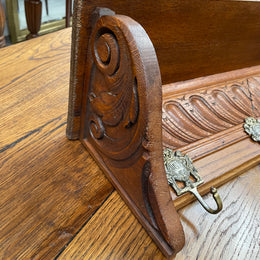 French oak wall coat rack with four decorative hooks and shelf. It has been sourced from France and is in good original condition. 