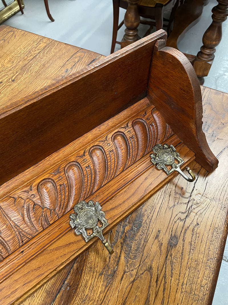 French oak wall coat rack with four decorative hooks and shelf. It has been sourced from France and is in good original condition. 