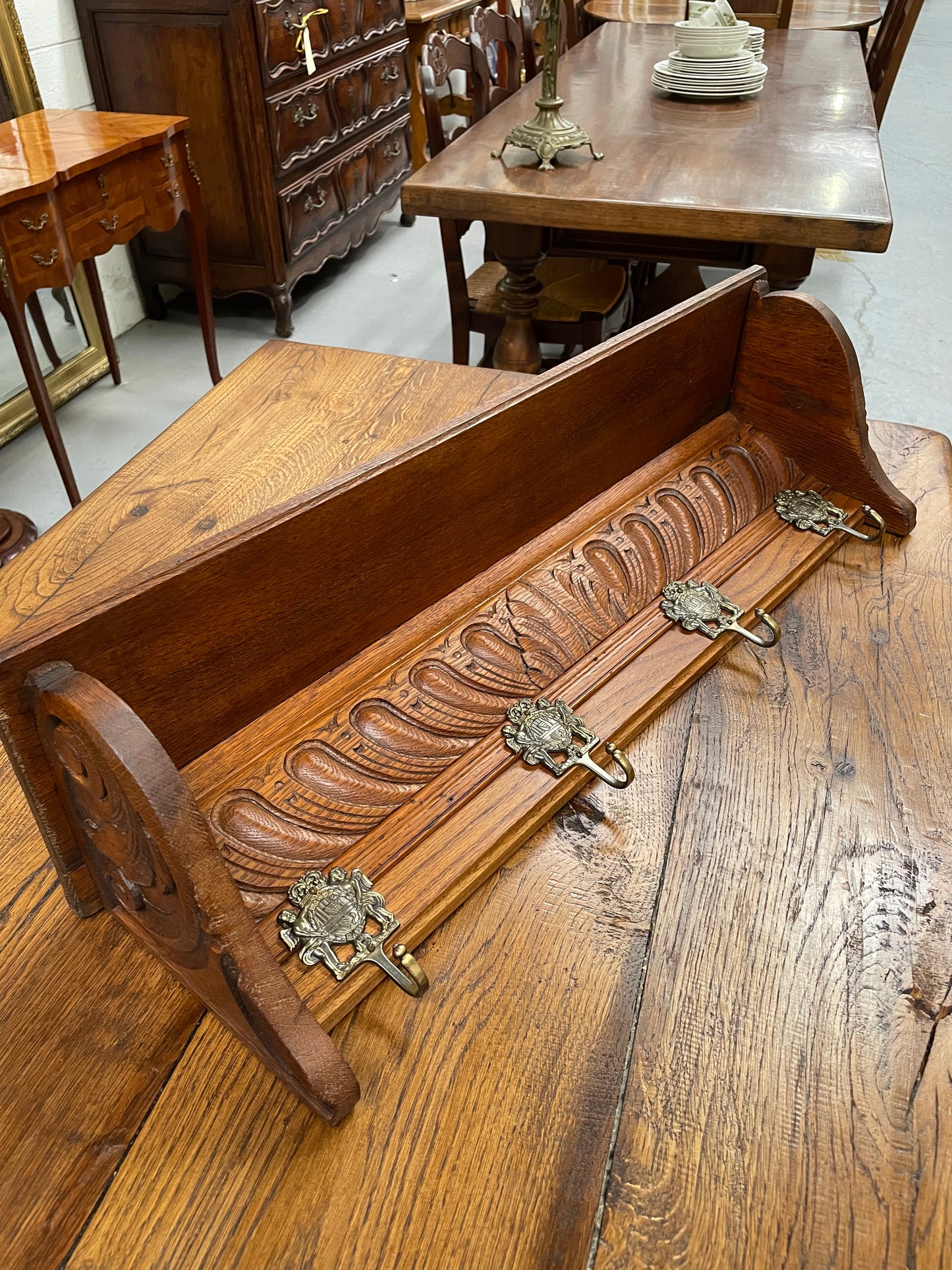 French oak wall coat rack with four decorative hooks and shelf. It has been sourced from France and is in good original condition. 