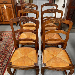 Lovely set of six French rush seat dining chairs. They feature decorative carved detailing particularly to the top of the chair. They are in good original detailed condition and have been sourced from France. 