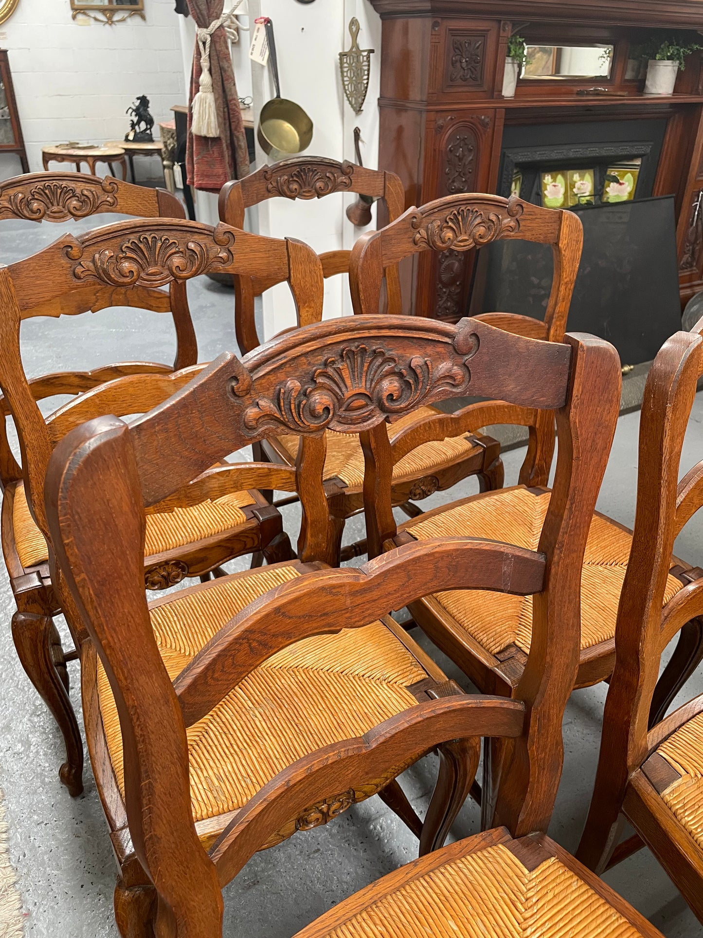 Lovely set of six French rush seat dining chairs. They feature decorative carved detailing particularly to the top of the chair. They are in good original detailed condition and have been sourced from France. 
