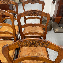 Lovely set of six French rush seat dining chairs. They feature decorative carved detailing particularly to the top of the chair. They are in good original detailed condition and have been sourced from France. 