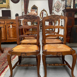 Lovely set of six French rush seat dining chairs. They feature decorative carved detailing particularly to the top of the chair. They are in good original detailed condition and have been sourced from France. 