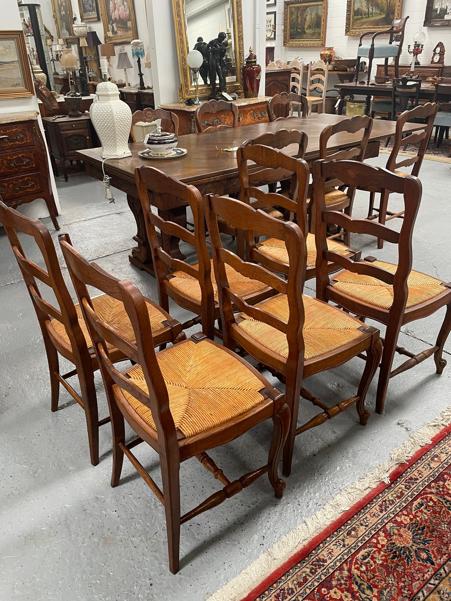 Lovely set of six French rush seat dining chairs. They feature decorative carved detailing particularly to the top of the chair. They are in good original detailed condition and have been sourced from France. 