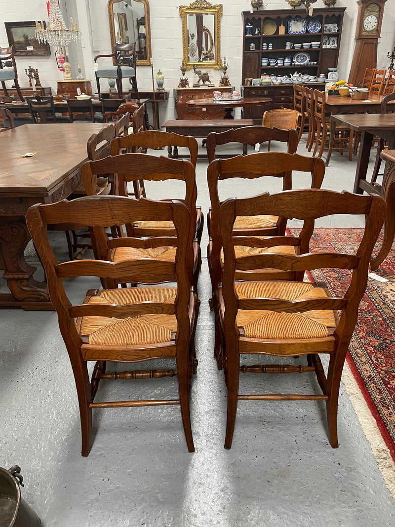 Lovely set of six French rush seat dining chairs. They feature decorative carved detailing particularly to the top of the chair. They are in good original detailed condition and have been sourced from France. 