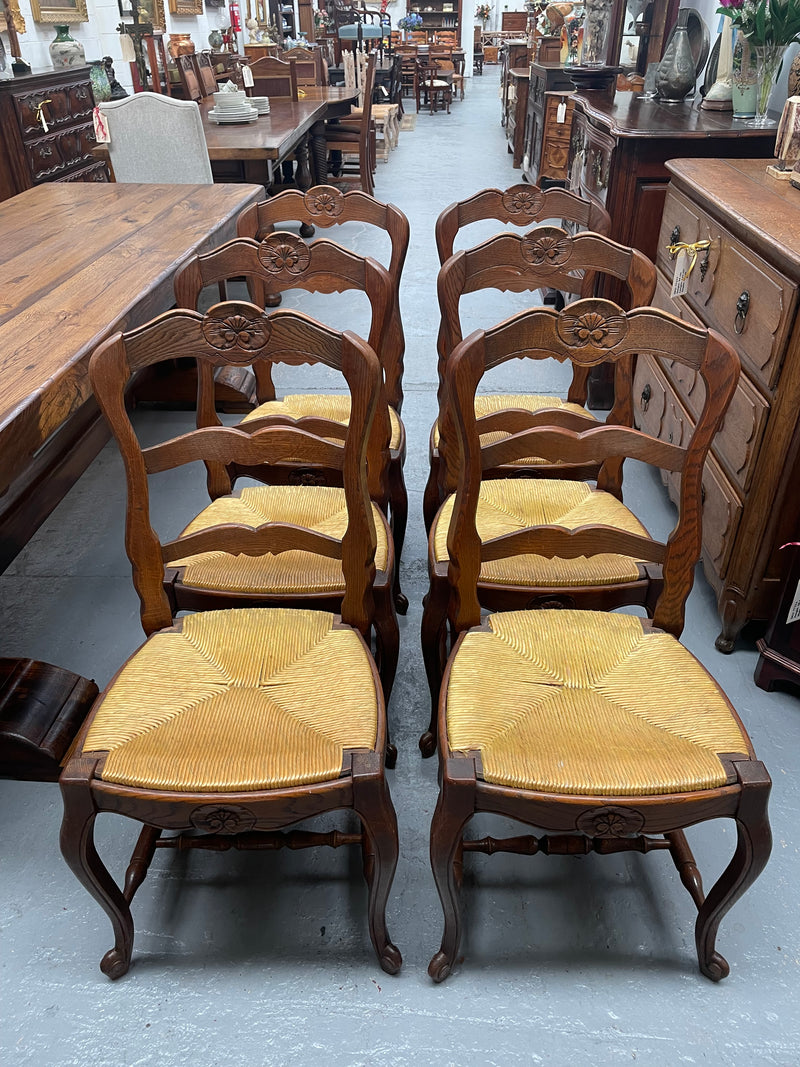 Set of six French Oak Louis XV style rush seat dining chairs . Nicely carved details and they have been sourced directly from France. They are in good original detailed condition.