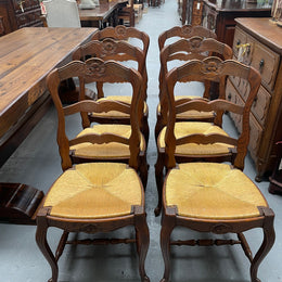 Set of six French Oak Louis XV style rush seat dining chairs . Nicely carved details and they have been sourced directly from France. They are in good original detailed condition.