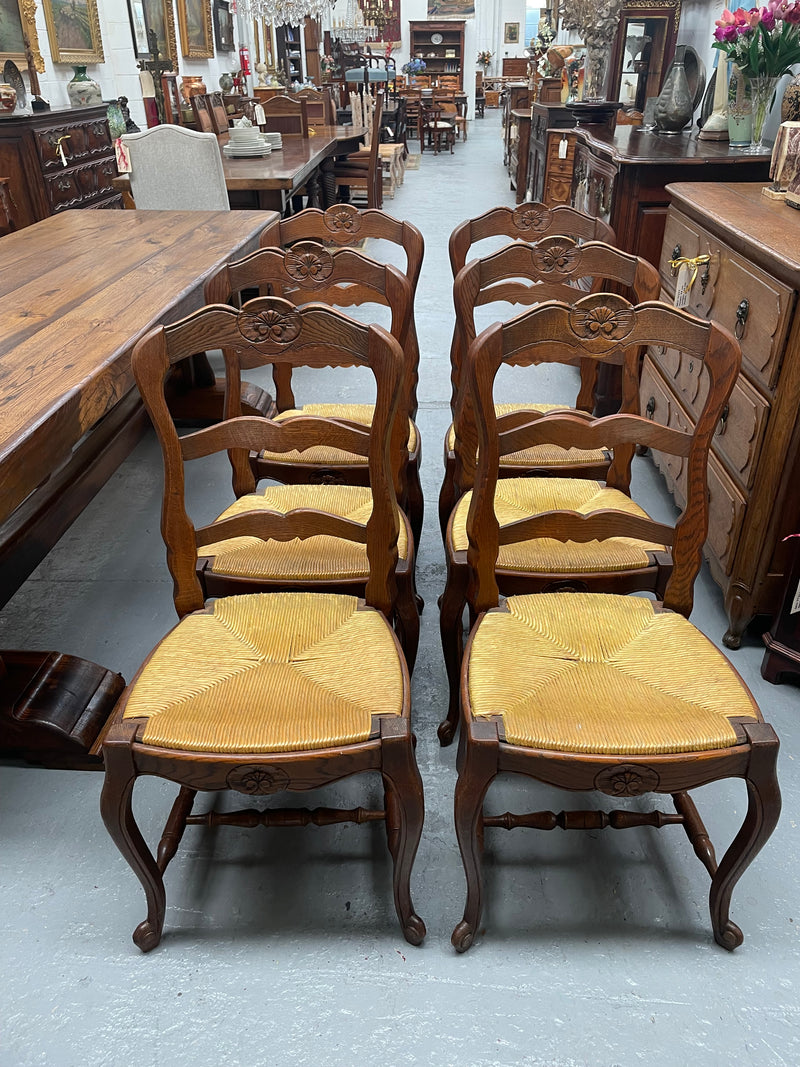 Set of six French Oak Louis XV style rush seat dining chairs . Nicely carved details and they have been sourced directly from France. They are in good original detailed condition.