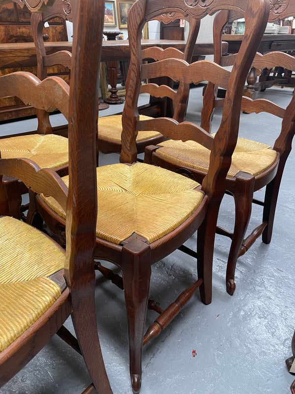 Set of six French Oak Louis XV style rush seat dining chairs . Nicely carved details and they have been sourced directly from France. They are in good original detailed condition.