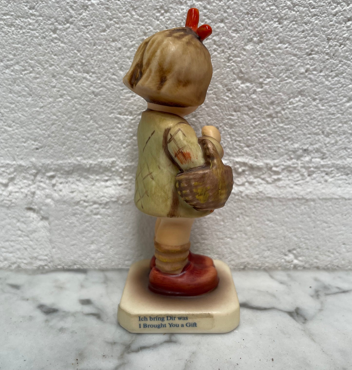 Beautiful Hummel Figurine "I Bought You a Gift", of a girl with her basket. In good original condition. Please see photos as they form part of the description.