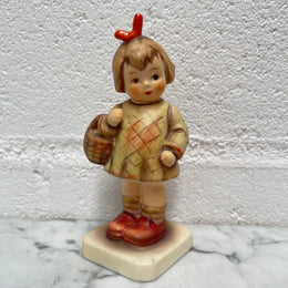 Beautiful Hummel Figurine "I Bought You a Gift", of a girl with her basket. In good original condition. Please see photos as they form part of the description.