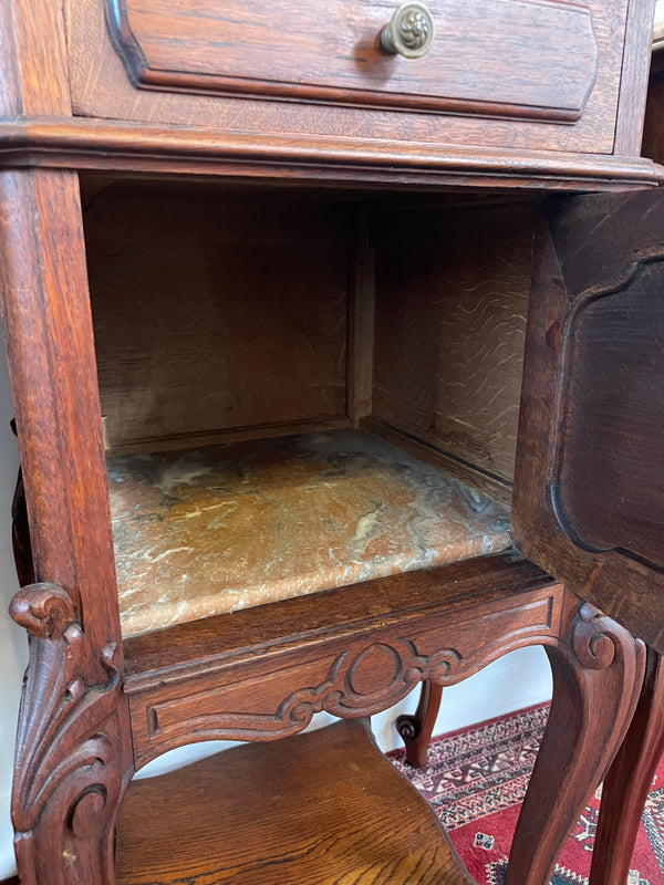 Beautifully carved pair of French Oak bedside cabinets with marble tops and inserts . They consist of one drawer and one cupboard. Featuring classic Louis 15th style curved legs and in good original detailed condition. They have been imported directly from France. 