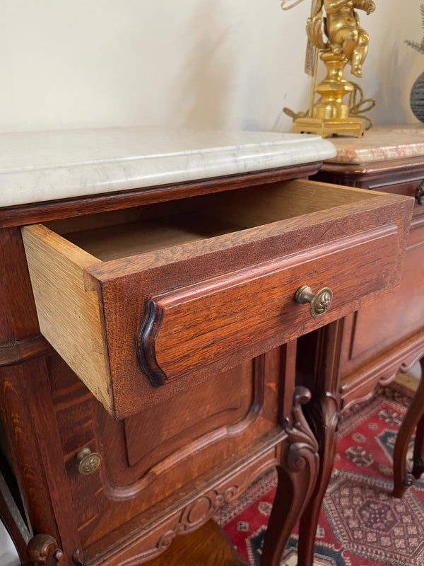 Beautifully carved pair of French Oak bedside cabinets with marble tops and inserts . They consist of one drawer and one cupboard. Featuring classic Louis 15th style curved legs and in good original detailed condition. They have been imported directly from France. 