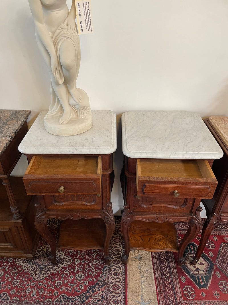 Beautifully carved pair of French Oak bedside cabinets with marble tops and inserts . They consist of one drawer and one cupboard. Featuring classic Louis 15th style curved legs and in good original detailed condition. They have been imported directly from France. 