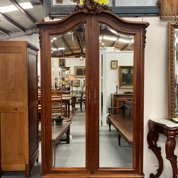 French Walnut Louis XV style two mirrored door armoire. It has four full adjustable shelves and two drawers at the bottom with one that locks. It has been sourced directly from France and is in good original detailed condition.