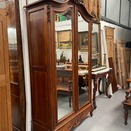 French Walnut Louis XV style two mirrored door armoire. It has four full adjustable shelves and two drawers at the bottom with one that locks. It has been sourced directly from France and is in good original detailed condition.