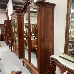 French Walnut Louis XV style two mirrored door armoire. It has four full adjustable shelves and two drawers at the bottom with one that locks. It has been sourced directly from France and is in good original detailed condition.