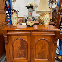 Cedar cupboard / side cabinet with two drawers above a pair of figured paneled doors, decorated with two corbels and on a plinth base. In good original condition and sourced locally.