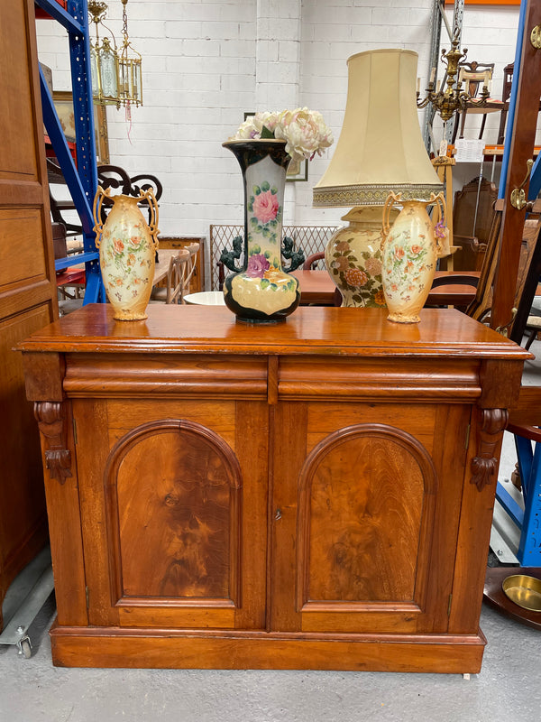 Cedar cupboard / side cabinet with two drawers above a pair of figured paneled doors, decorated with two corbels and on a plinth base. In good original condition and sourced locally.