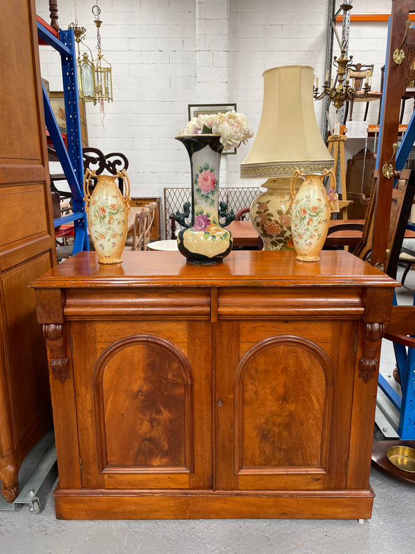 Cedar cupboard / side cabinet with two drawers above a pair of figured paneled doors, decorated with two corbels and on a plinth base. In good original condition and sourced locally.