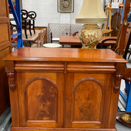 Cedar cupboard / side cabinet with two drawers above a pair of figured paneled doors, decorated with two corbels and on a plinth base. In good original condition and sourced locally.