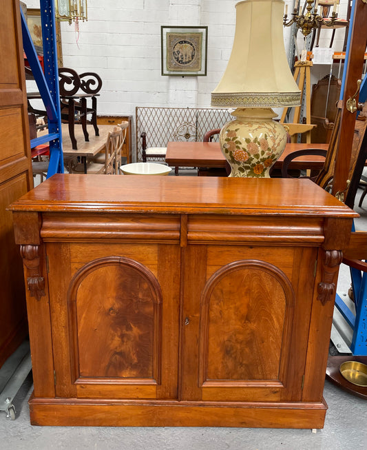 Cedar cupboard / side cabinet with two drawers above a pair of figured paneled doors, decorated with two corbels and on a plinth base. In good original condition and sourced locally.