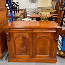 Cedar cupboard / side cabinet with two drawers above a pair of figured paneled doors, decorated with two corbels and on a plinth base. In good original condition and sourced locally.