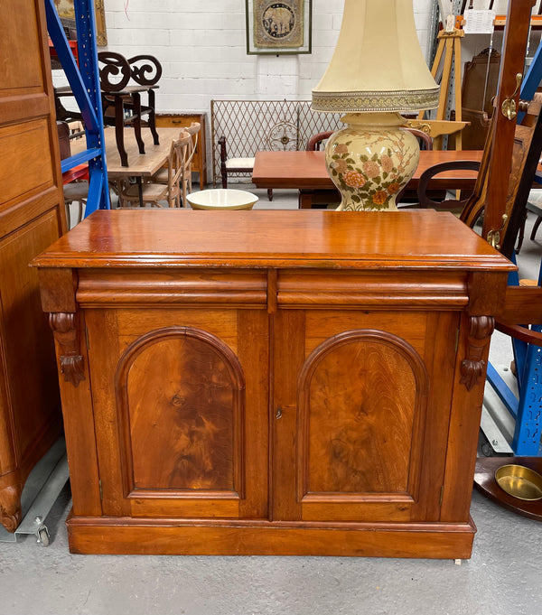 Cedar cupboard / side cabinet with two drawers above a pair of figured paneled doors, decorated with two corbels and on a plinth base. In good original condition and sourced locally.