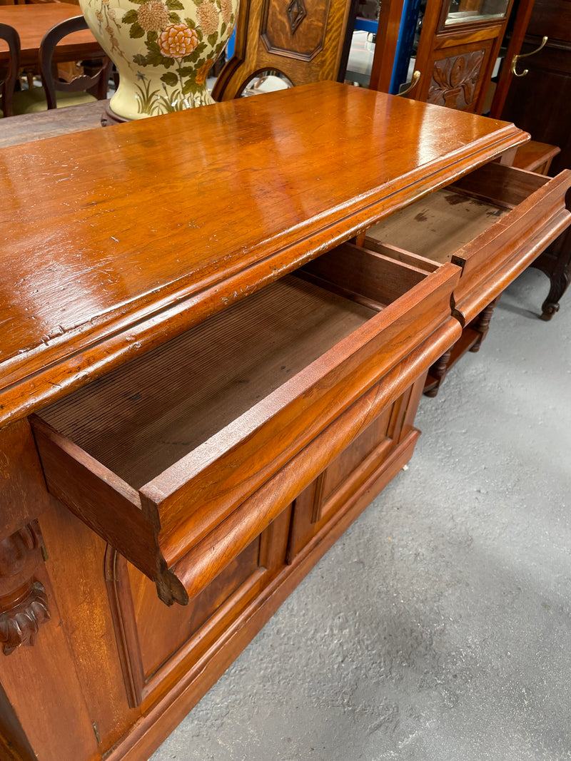 Cedar cupboard / side cabinet with two drawers above a pair of figured paneled doors, decorated with two corbels and on a plinth base. In good original condition and sourced locally.