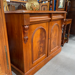 Cedar cupboard / side cabinet with two drawers above a pair of figured paneled doors, decorated with two corbels and on a plinth base. In good original condition and sourced locally.