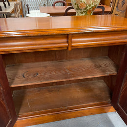 Cedar cupboard / side cabinet with two drawers above a pair of figured paneled doors, decorated with two corbels and on a plinth base. In good original condition and sourced locally.