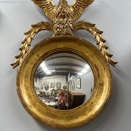 A stunning round carved wooden eagle convex hanging mirror. The eagle theme adds a touch of elegance and sophistication to your décor. It is in good as found condition.
