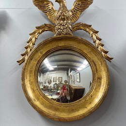 A stunning round carved wooden eagle convex hanging mirror. The eagle theme adds a touch of elegance and sophistication to your décor. It is in good as found condition.