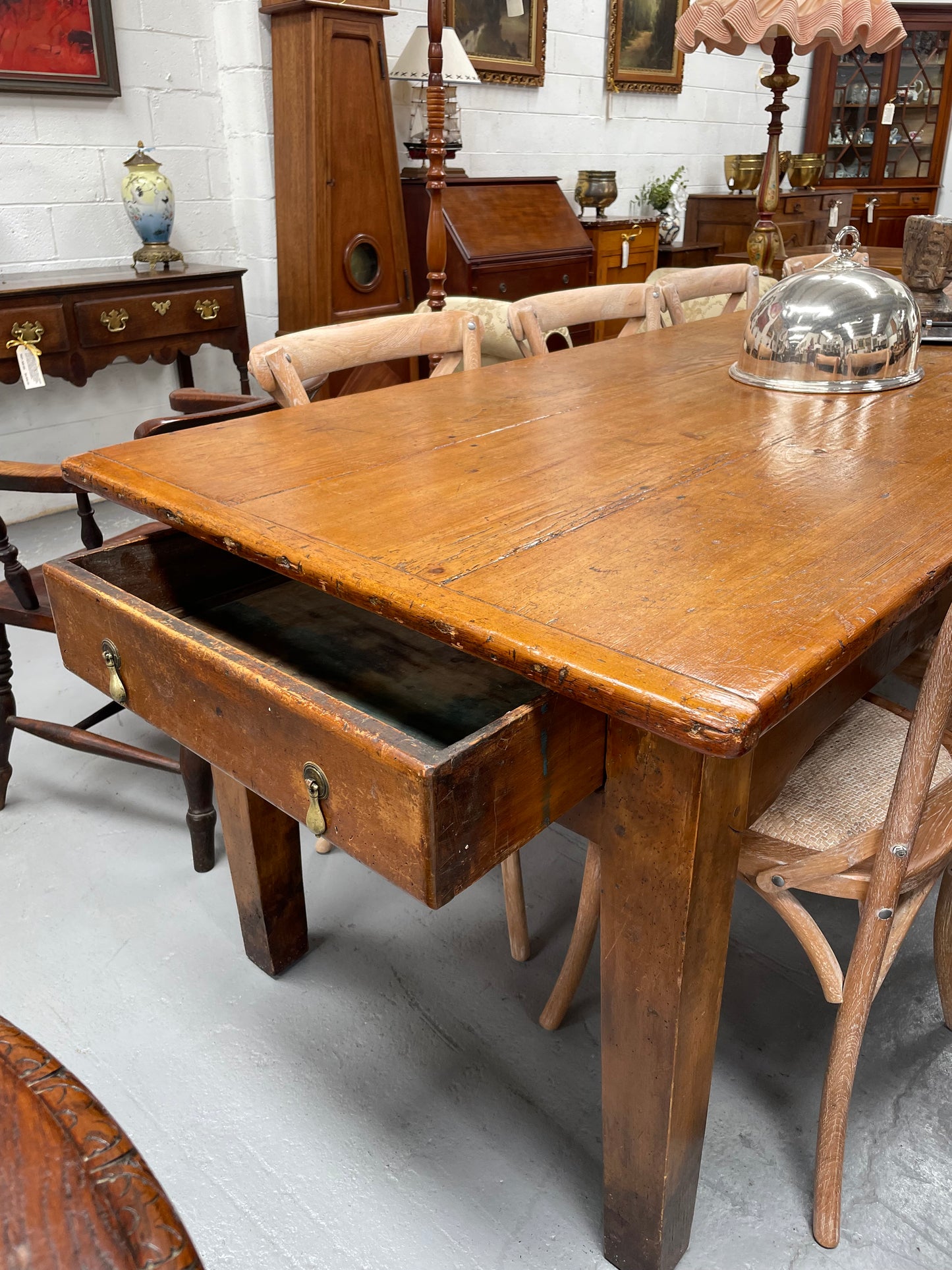 This table stands on four tapered legs supporting the main section. There are four sides with an original long drawer to each end. The top is in good condition commensurate with age and consists of three thick wide planks. The table is very strong and sturdy.