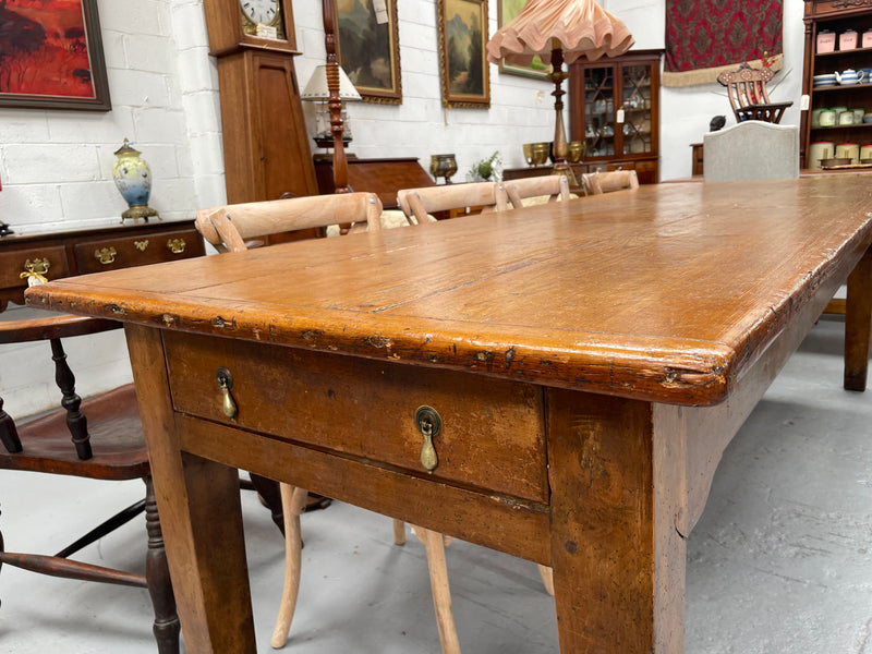 This table stands on four tapered legs supporting the main section. There are four sides with an original long drawer to each end. The top is in good condition commensurate with age and consists of three thick wide planks. The table is very strong and sturdy.