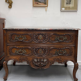 Highly decorative Louis XIV black marble topped two drawer commode. Featuring carved drawer fronts, brass handles and escutcheons. In good detailed detailed condition. 