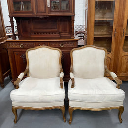Pair of vintage Louis 15th style oak framed bergeres chairs with good size seats. making them very comfortable to sit in. The upholstery is in used condition with stains as shown in photos. Overall the timber frames are strong &amp; solid. They have been sourced directly from France. 