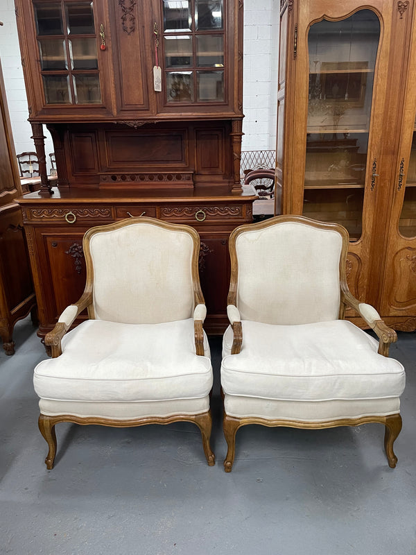 Pair of vintage Louis 15th style oak framed bergeres chairs with good size seats. making them very comfortable to sit in. The upholstery is in used condition with stains as shown in photos. Overall the timber frames are strong &amp; solid. They have been sourced directly from France. 