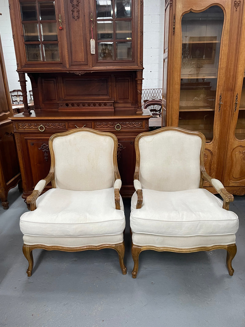 Pair of vintage Louis 15th style oak framed bergeres chairs with good size seats. making them very comfortable to sit in. The upholstery is in used condition with stains as shown in photos. Overall the timber frames are strong &amp; solid. They have been sourced directly from France. 